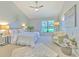 Serene main bedroom with a cozy seating area, ceiling fan, and a large window overlooking the lawn at 2309 Mooney. Pl, Sun City Center, FL 33573