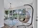 Bright sitting area with modern furniture, a hanging chair, and large windows overlooking the landscaped yard at 2309 Mooney. Pl, Sun City Center, FL 33573