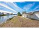 Waterfront backyard with expansive water view and a white stucco home with a covered patio at 3396 Minnow Creek Dr, Hernando Beach, FL 34607