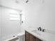 Bathroom featuring tiled shower, dark vanity with white countertop, and window for natural light at 3396 Minnow Creek Dr, Hernando Beach, FL 34607