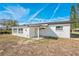 Exterior view of a newly painted white home with a covered patio and several windows at 3396 Minnow Creek Dr, Hernando Beach, FL 34607