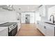 Modern kitchen with stainless steel appliances, sleek white cabinets, a large island, and a quartz countertop at 3396 Minnow Creek Dr, Hernando Beach, FL 34607