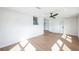 Living room with light wood floor, fan and view of the kitchen through serving window at 3396 Minnow Creek Dr, Hernando Beach, FL 34607