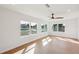 Bright living room featuring wood floors, ceiling fan and many windows looking out on a waterway at 3396 Minnow Creek Dr, Hernando Beach, FL 34607