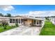 Cozy one story home featuring ample parking, a sun room, and a lush lawn at 35801 Verda Dr, Zephyrhills, FL 33541