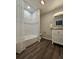 Bright bathroom with a white tiled shower-tub, contemporary fixtures, and wood-style flooring at 3763 Dartmouth N Ave, St Petersburg, FL 33713