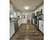 Galley kitchen featuring stainless appliances, wood-look flooring, and white cabinets at 3763 Dartmouth N Ave, St Petersburg, FL 33713