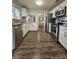 Open kitchen features stainless steel appliances, granite counters, and wood laminate flooring at 3763 Dartmouth N Ave, St Petersburg, FL 33713