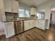 Bright kitchen with white cabinets, granite counters, stainless steel dishwasher and wood-look flooring at 3763 Dartmouth N Ave, St Petersburg, FL 33713
