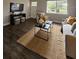 Cozy living room featuring dark wood floors, a modern TV setup, and a stylish jute rug at 3763 Dartmouth N Ave, St Petersburg, FL 33713