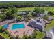 Aerial view of community pool area with lap lanes, seating, wading pool, clubhouse and verdant landscaping at 6527 Stonington Dr, Tampa, FL 33647