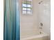 Shower with blue curtain and tiled wall with window at 6527 Stonington Dr, Tampa, FL 33647