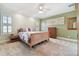 Inviting bedroom featuring a comfortable bed, neutral carpet, and bright shuttered windows at 6527 Stonington Dr, Tampa, FL 33647