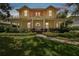Charming yellow two-story home with a welcoming front porch and beautifully landscaped front yard at 6527 Stonington Dr, Tampa, FL 33647