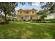 Charming yellow two-story home featuring a manicured lawn and inviting front porch at 6527 Stonington Dr, Tampa, FL 33647