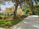 Spacious two-story yellow home with a long driveway, manicured lawn, and a welcoming front porch at 6527 Stonington Dr, Tampa, FL 33647