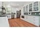 Bright kitchen featuring stainless steel appliances, white cabinets, and hardwood flooring at 6527 Stonington Dr, Tampa, FL 33647