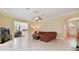 Spacious living room featuring tile floors, ceiling fan, and views of kitchen and entry hallway at 6527 Stonington Dr, Tampa, FL 33647