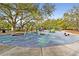 A large, well-maintained community playground with various play structures, a rubber surface, and mature trees at 6527 Stonington Dr, Tampa, FL 33647