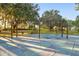 Community playground with swings and benches, surrounded by mature trees and green space at 6527 Stonington Dr, Tampa, FL 33647