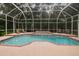 Private screened-in pool with a jacuzzi, brick paver deck, and lush landscaping at 6527 Stonington Dr, Tampa, FL 33647