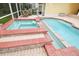 Inviting pool and jacuzzi featuring brick trim and pavers, perfect for relaxation at 6527 Stonington Dr, Tampa, FL 33647