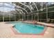 Private screened-in pool with a jacuzzi, brick paver deck, and lush landscaping at 6527 Stonington Dr, Tampa, FL 33647