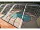 Enclosed pool area with a sparkling pool and a hot tub surrounded by a screened enclosure at 6527 Stonington Dr, Tampa, FL 33647