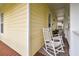 Relaxing front porch featuring classic white rocking chairs and wood floors at 6527 Stonington Dr, Tampa, FL 33647