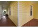 Wide porch with wood floors and yellow wood siding along the side of this lovely home at 6527 Stonington Dr, Tampa, FL 33647