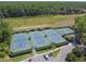 Aerial view of multiple tennis courts in a community, surrounded by green landscaping and parking at 6527 Stonington Dr, Tampa, FL 33647