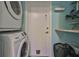 Bright laundry room with stackable washer and dryer, and built-in shelving at 2447 Nantucket Harbor Loop # 112, Sun City Center, FL 33573