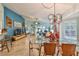 Bright dining room with glass table and mid-century modern chairs, open to the living room and kitchen at 2447 Nantucket Harbor Loop # 112, Sun City Center, FL 33573