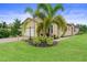 Tan house with tile roof, palm trees, and landscaped lawn at 5115 Tobermory Way, Bradenton, FL 34211