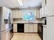 Kitchen with stainless steel appliances, white cabinets, and light-colored flooring at 35801 Verda Dr, Zephyrhills, FL 33541