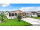 Tan single-wide manufactured home with carport, landscaping, and large windows at 35801 Verda Dr, Zephyrhills, FL 33541