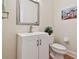 Small powder room with a white vanity, toilet, and framed mirror at 6527 Stonington Dr, Tampa, FL 33647