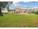 Large backyard with screened enclosure, lush lawn, and mature trees at 6527 Stonington Dr, Tampa, FL 33647