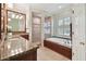 Elegant bathroom with soaking tub, shower, and granite countertops at 6527 Stonington Dr, Tampa, FL 33647