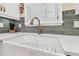 Modern farmhouse kitchen sink with white sink, bronze faucet, and gray tile backsplash at 6527 Stonington Dr, Tampa, FL 33647