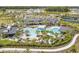 Aerial view of the community pool surrounded by palm trees and lounge chairs, near a lake and clubhouse at 18122 Sugar Brooke Dr, Tampa, FL 33647