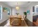 Farmhouse dining room with wood table, wainscoting, chandelier, and beach art at 18122 Sugar Brooke Dr, Tampa, FL 33647