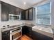 Modern kitchen with dark cabinets, stainless steel appliances, and subway tile backsplash at 18122 Sugar Brooke Dr, Tampa, FL 33647