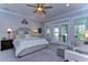 Serene main bedroom with a plush bed, ceiling fan, and French doors to a balcony at 18614 Hanna Rd, Lutz, FL 33549