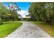 Gravel driveway curving to a charming house with lush green grass at 29249 Wilpayne Rd, Brooksville, FL 34602