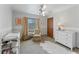Bright bedroom with a ceiling fan, dresser, and comfortable armchair at 29249 Wilpayne Rd, Brooksville, FL 34602