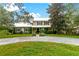 Two-story house with a metal roof, landscaping, and a gravel driveway at 29249 Wilpayne Rd, Brooksville, FL 34602