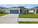 House exterior with a stone accent and a teal garage door at 6205 Golden Nettle Dr, Apollo Beach, FL 33572