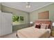 Bedroom featuring a large window, neutral carpet and a stylish bed with a pink tufted headboard at 13102 Prestwick Dr, Riverview, FL 33579