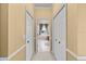 Hallway featuring neutral walls and trim, with access to closets and a view of the bathroom at 13102 Prestwick Dr, Riverview, FL 33579